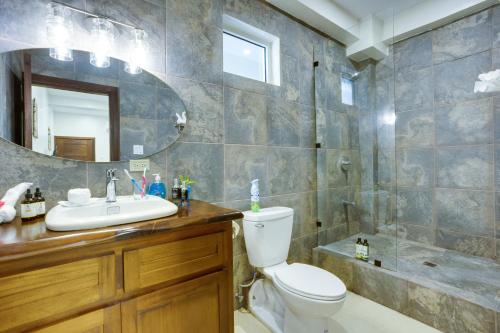 a bathroom with a toilet and a sink and a shower at Louis' Apartments in Placencia Village