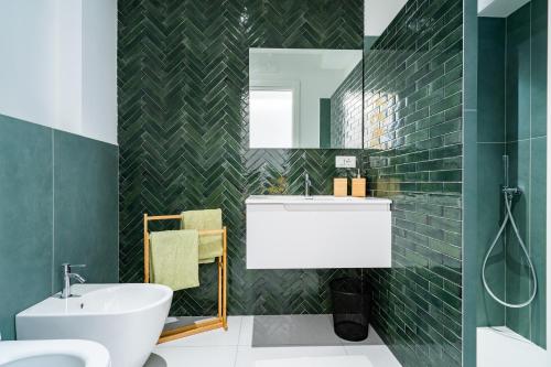 a bathroom with a white sink and green tiles at Villa Talia in Sorrento