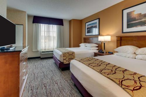 um quarto de hotel com duas camas e uma televisão de ecrã plano em Drury Inn & Suites Meridian em Meridian