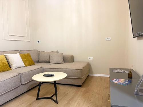 a living room with a couch and a table at 4 BR apartment & BBQ veranda in Tirana