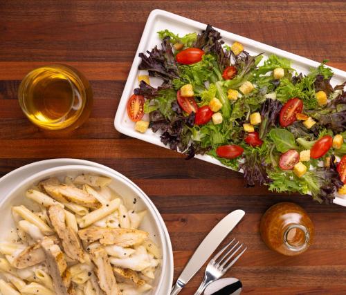 a table with a salad and a bowl of french fries at Drury Inn & Suites Lafayette IN in Lafayette