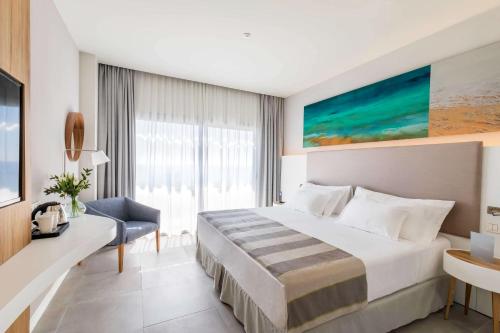 a hotel room with a bed and a large window at Barceló Conil Playa - Adults Recommended in Conil de la Frontera