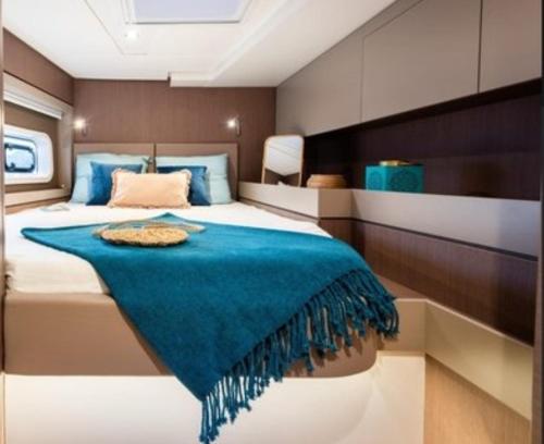 a bedroom with a large bed with a blue blanket at Catamaran baie des 3 ilets in Les Trois-Îlets
