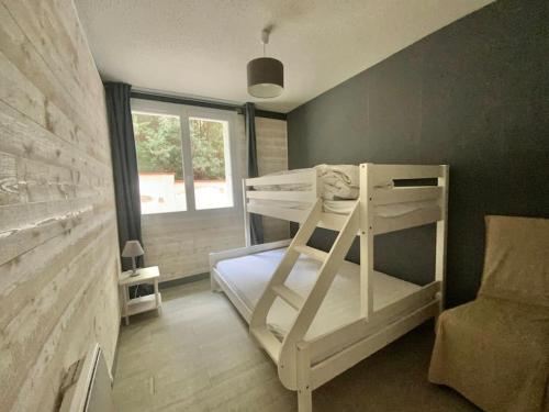 une chambre avec un lit superposé et une fenêtre dans l'établissement Appartement cosy en bord de mer, à La Tranche-sur-Mer