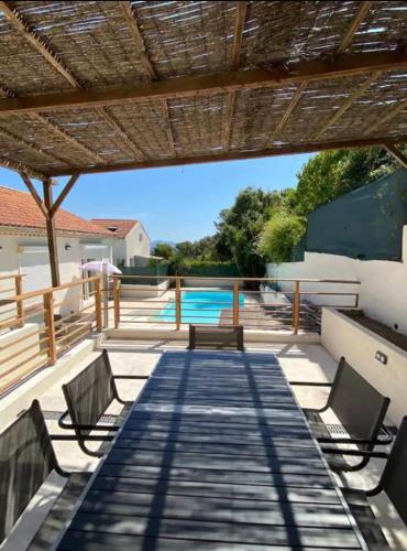 un patio avec deux bancs et une piscine dans l'établissement Villa avec piscine Mi Baou, à La Seyne-sur-Mer