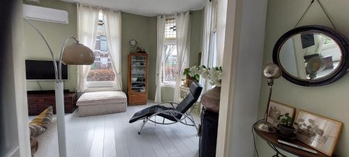 a living room with a mirror and a chair in it at Townhouse Center Arnhem in Arnhem