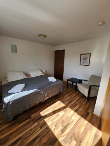 a bedroom with a bed and a couch and wooden floors at Fjós Guesthouse in Varmahlid