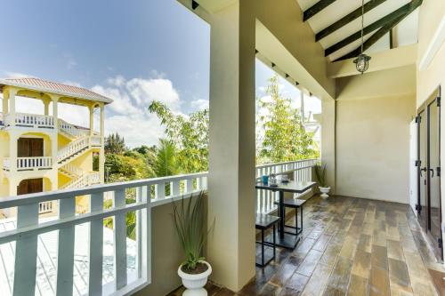 a balcony of a house with a table and chairs at Louis' Apartments in Placencia Village