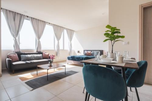 a living room with a table and blue chairs at Isolda Suites Vistas del Bosque in Mexico City