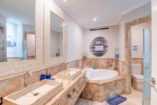 een badkamer met een bad, een wastafel en een toilet bij FISHING LODGE, INFINITY POOL, VISTAS A LA BAHIA in Punta Cana
