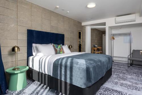 a bedroom with a large bed with a blue headboard at Arluxia in Auckland