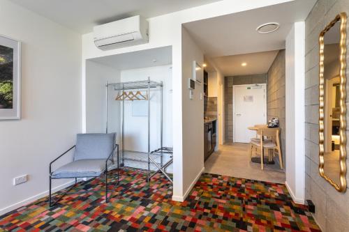a living room with a chair and a hallway at Arluxia in Auckland