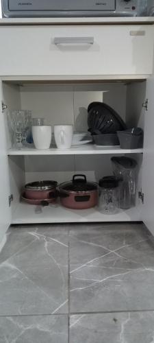 a kitchen shelf with dishes and bowls on it at Monoambiente Eldorado I in Eldorado