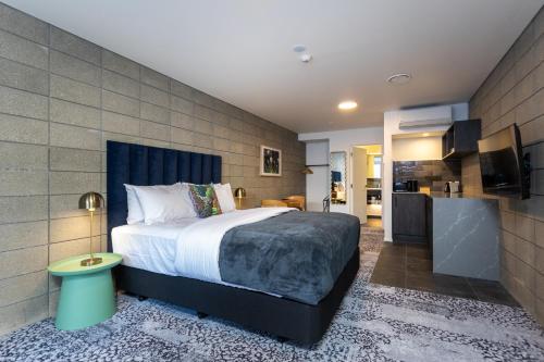 a bedroom with a large bed and a kitchen at Arluxia in Auckland