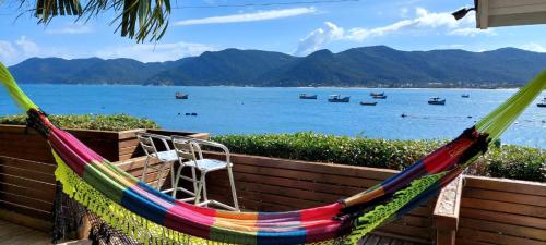 a hammock with a view of the water and boats at Casa no Paraíso - Pântano do Sul - Florianópolis in Florianópolis