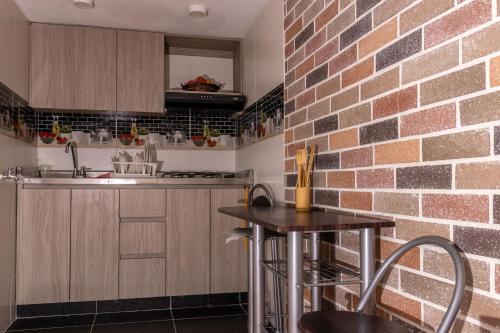 a kitchen with a table and a brick wall at Hospedaje juandi in Medellín