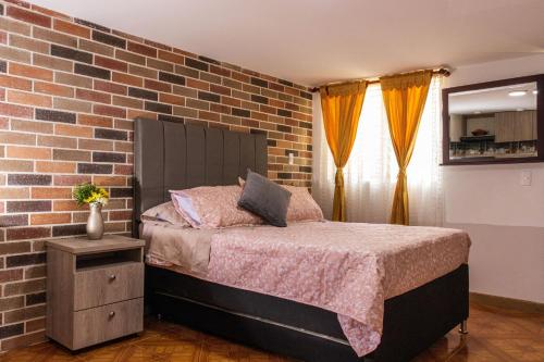 麥德林的住宿－Hospedaje juandi，一间卧室设有砖墙和一张床