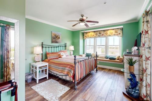 Dormitorio verde con cama y ventana en Sunrise Paradise, en Hatteras