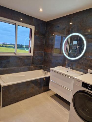 une salle de bain avec un lavabo et une machine à laver dans l'établissement Villa 220 m2 avec 5 chambres 6 lits doubles 2 toilettes 2 salles de bain, à Beire-le-Châtel