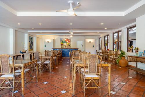 a room with chairs and tables and a ceiling at Pousada Porto Fino in Cabo Frio