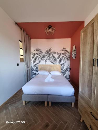 une chambre avec un lit blanc avec un tableau sur le mur dans l'établissement Croisette à 2 min : Vivez la magie de Cannes !, à Cannes