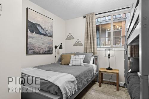 a bedroom with a bed and a window at Mystic Mountain Chalet, Heated Outdoor Pool & Hot Tub, Free Parking, Fast Wifi! in Canmore