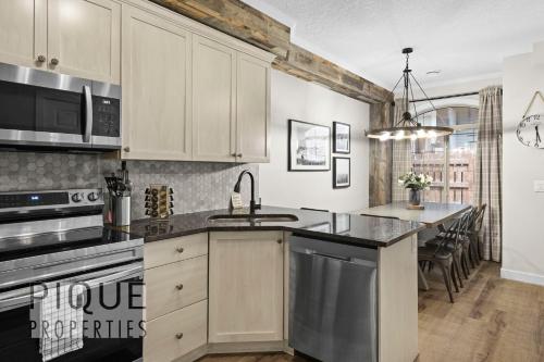 a kitchen with a sink and a stove top oven at Mystic Mountain Chalet, Heated Outdoor Pool & Hot Tub, Free Parking, Fast Wifi! in Canmore
