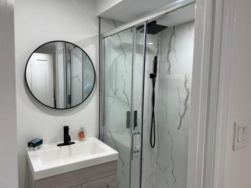 a bathroom with a shower and a sink and a mirror at Cozy, brand-new, 2BDR,walkout apt, free parking in Richmond Hill