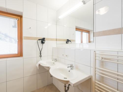 a white bathroom with a sink and a mirror at Reiterblick Ski in - Ski Out in Saalbach Hinterglemm