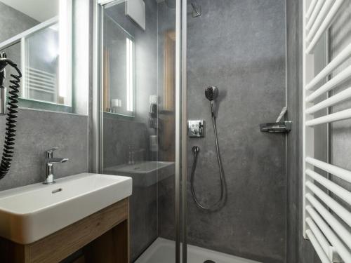 a bathroom with a sink and a shower at Traumlage Ski in - Ski out in Saalbach Hinterglemm