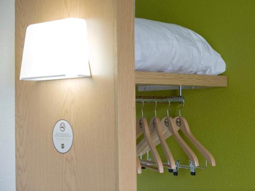 a room with a bed and a light on a wall at B&B HOTEL près de Disneyland Paris in Magny-le-Hongre