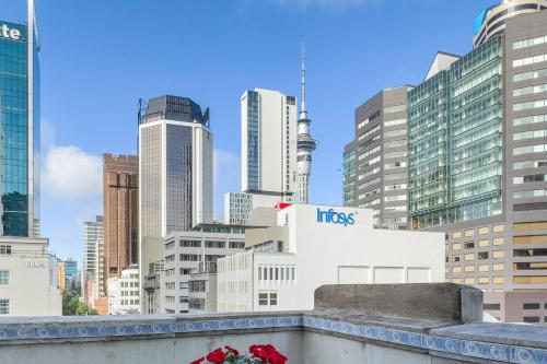 a view of theuckland city skyline with roses on a ledge at Dilworth Apartments by Urban Rest in Auckland