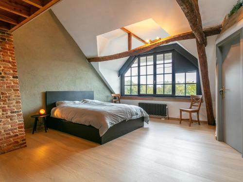 een slaapkamer met een bed en een groot raam bij Alverwege 2 in Merksplas