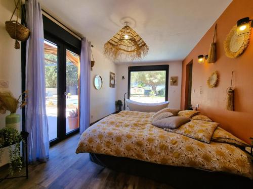 ein Schlafzimmer mit einem Bett und einem großen Fenster in der Unterkunft Le Catamaran in Sallèles-dʼAude