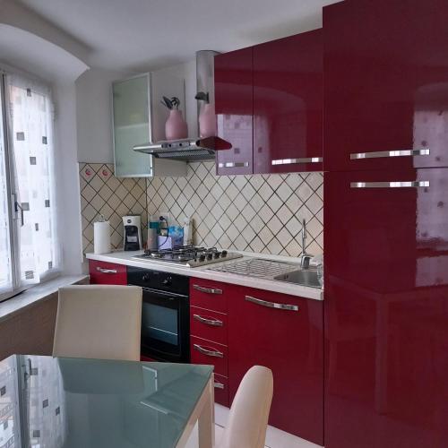 a kitchen with red cabinets and a sink at Casa Caia in Genoa