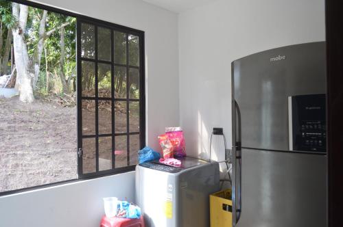 a kitchen with a refrigerator and a window at Quinta Rousse in Santa Isabel