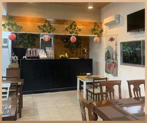 um restaurante com uma sala de jantar com mesas e cadeiras em Axis Pension Hotel em Mactan