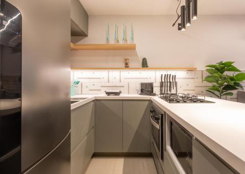 a kitchen with white cabinets and a stove at Loft com jacuzzi privativa frente mar do Bessa in João Pessoa