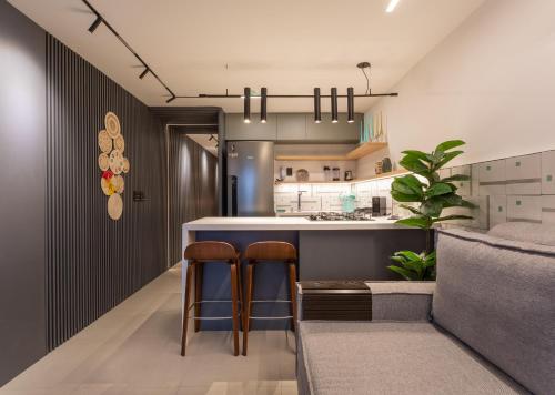 a kitchen with two bar stools and a counter at Loft com jacuzzi privativa frente mar do Bessa in João Pessoa