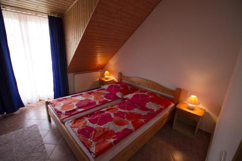 ザラカロシュにあるRelax Apartment Houseのベッドルーム1室(ベッド1台、2つのテーブルに照明付)