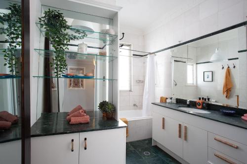 a bathroom with a sink and a bath tub at Modern Muse, Bellevue Hill in Sydney