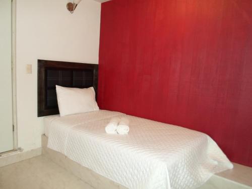 a bedroom with a bed with two white towels on it at Hotel María Bonita in Tlaxcala de Xicohténcatl