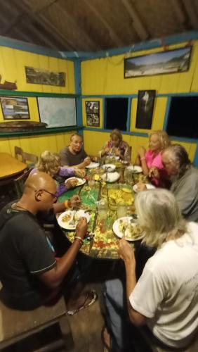 a group of people sitting around a table eating food at 4 Pohon - Les 4 Arbres in Pandang