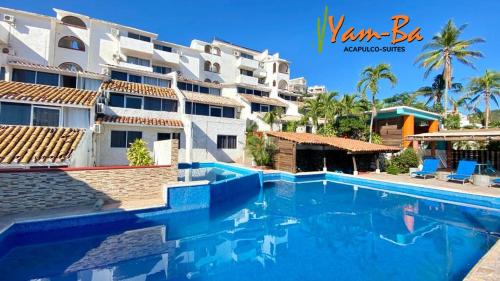a swimming pool in front of a building at Suites Acapulco Yamba in Acapulco