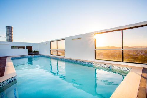 a large swimming pool in a house with windows at Hotel Grand Chancellor Brisbane in Brisbane