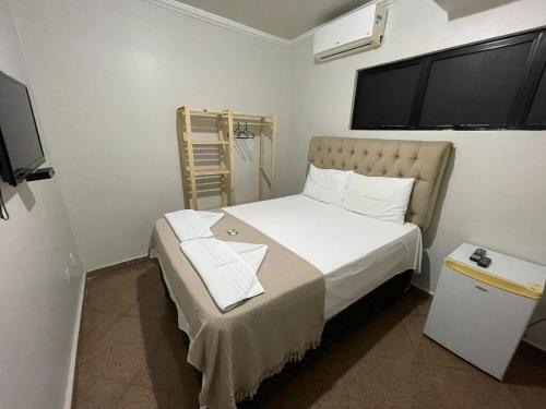 Dormitorio pequeño con cama y TV en Pousada Maré Alta Maceió en Maceió