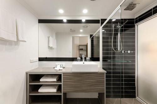 uma casa de banho com um lavatório e um chuveiro em Hotel Grand Chancellor Brisbane em Brisbane