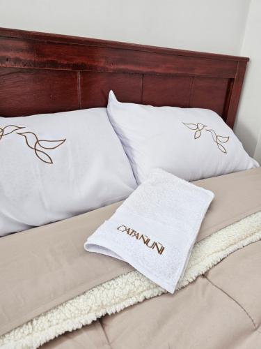 a bed with two white pillows on it at catañuñi in Huancayo