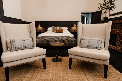 sypialnia z 2 krzesłami i łóżkiem w obiekcie The Victoria Hotel Rutherglen w mieście Rutherglen