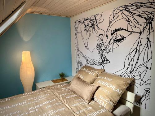 Schlafzimmer mit einem Bett mit Wandzeichnung in der Unterkunft neXt doOr Donau Gästezimmer und Suite in Wurmlingen
